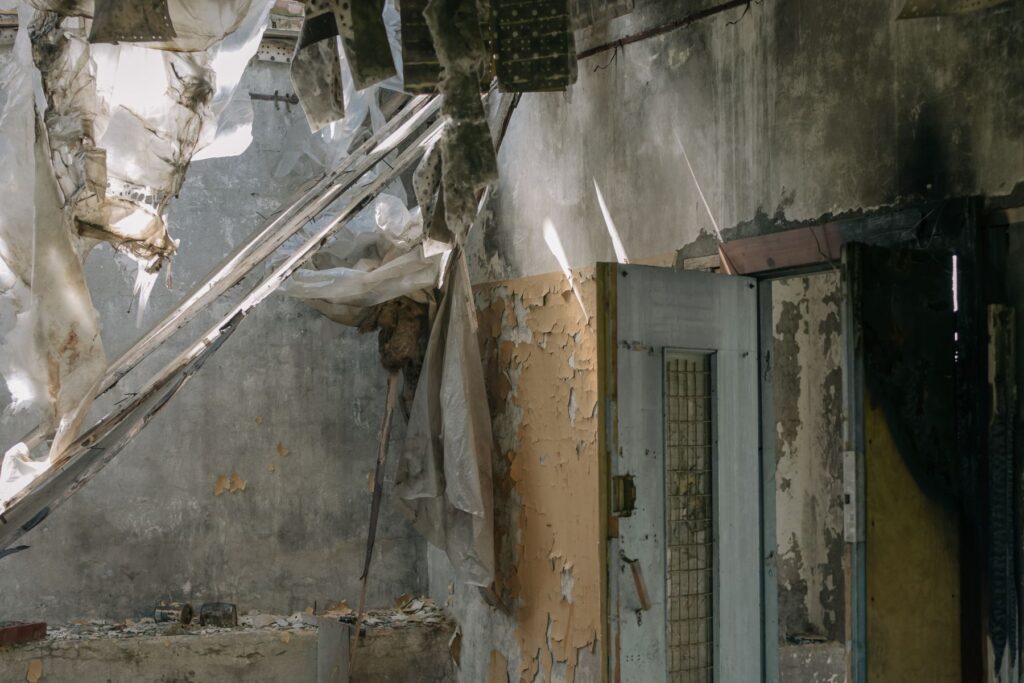 Damaged interior with peeling walls and exposed materials