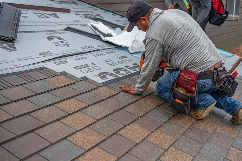 Roofer installing shingles on a house