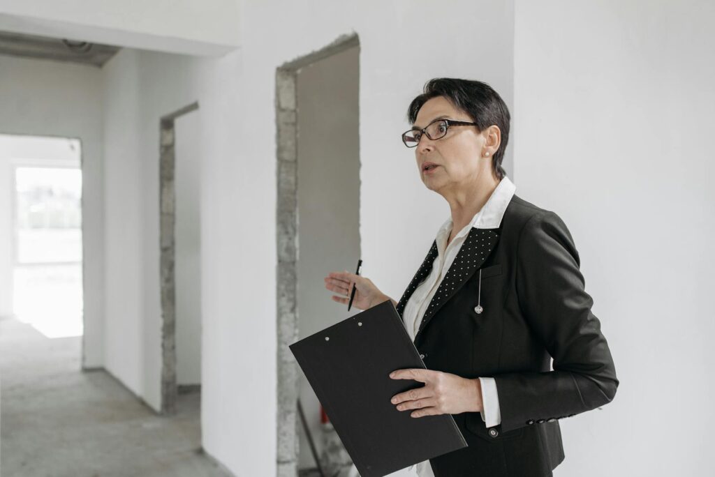 Home inspector with clipboard in unfinished interior