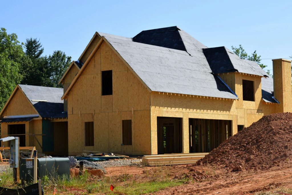 New home under construction with exposed framing and roof sheathing
