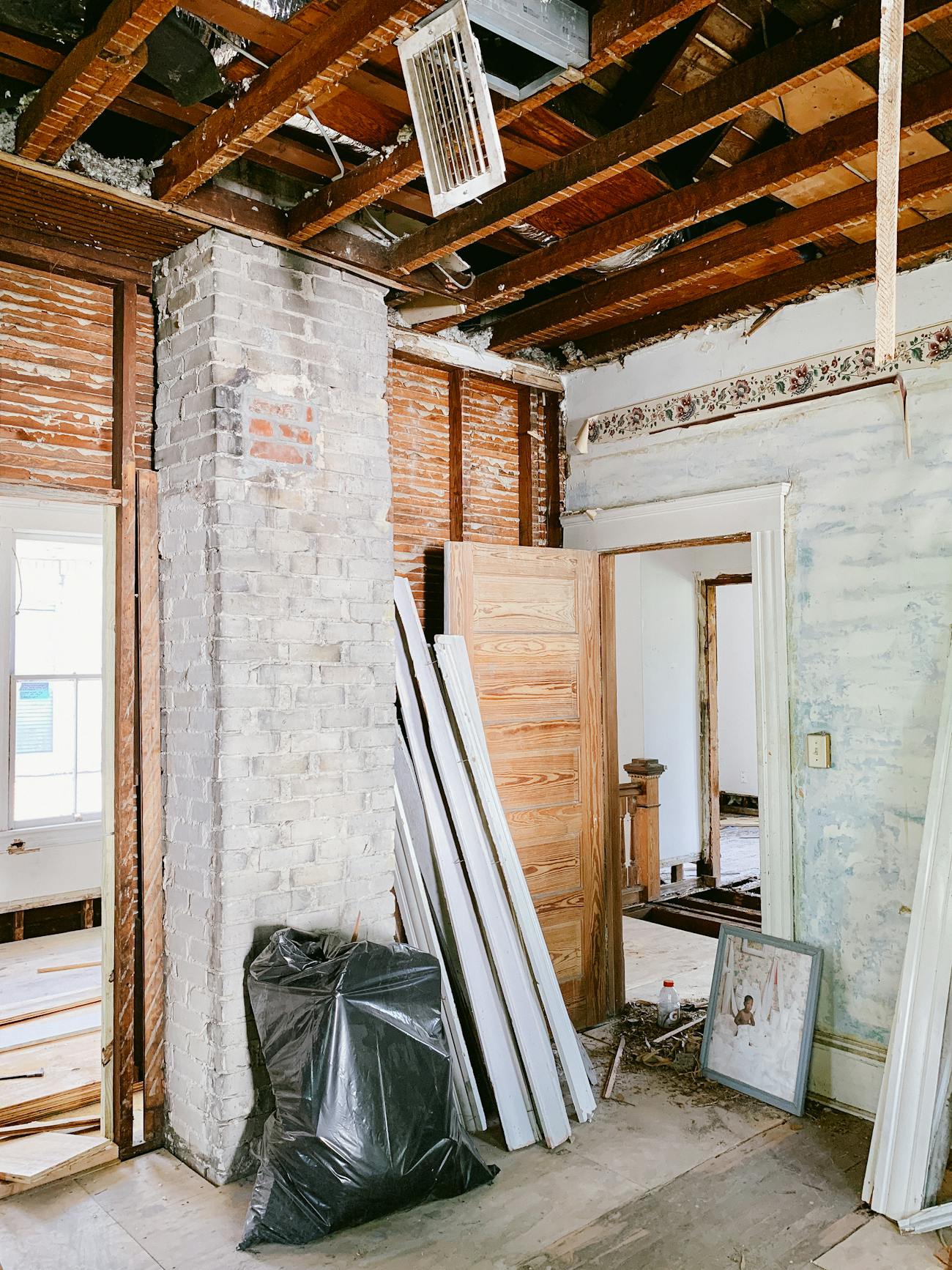 Interior renovation with exposed beams, brick, and building materials
