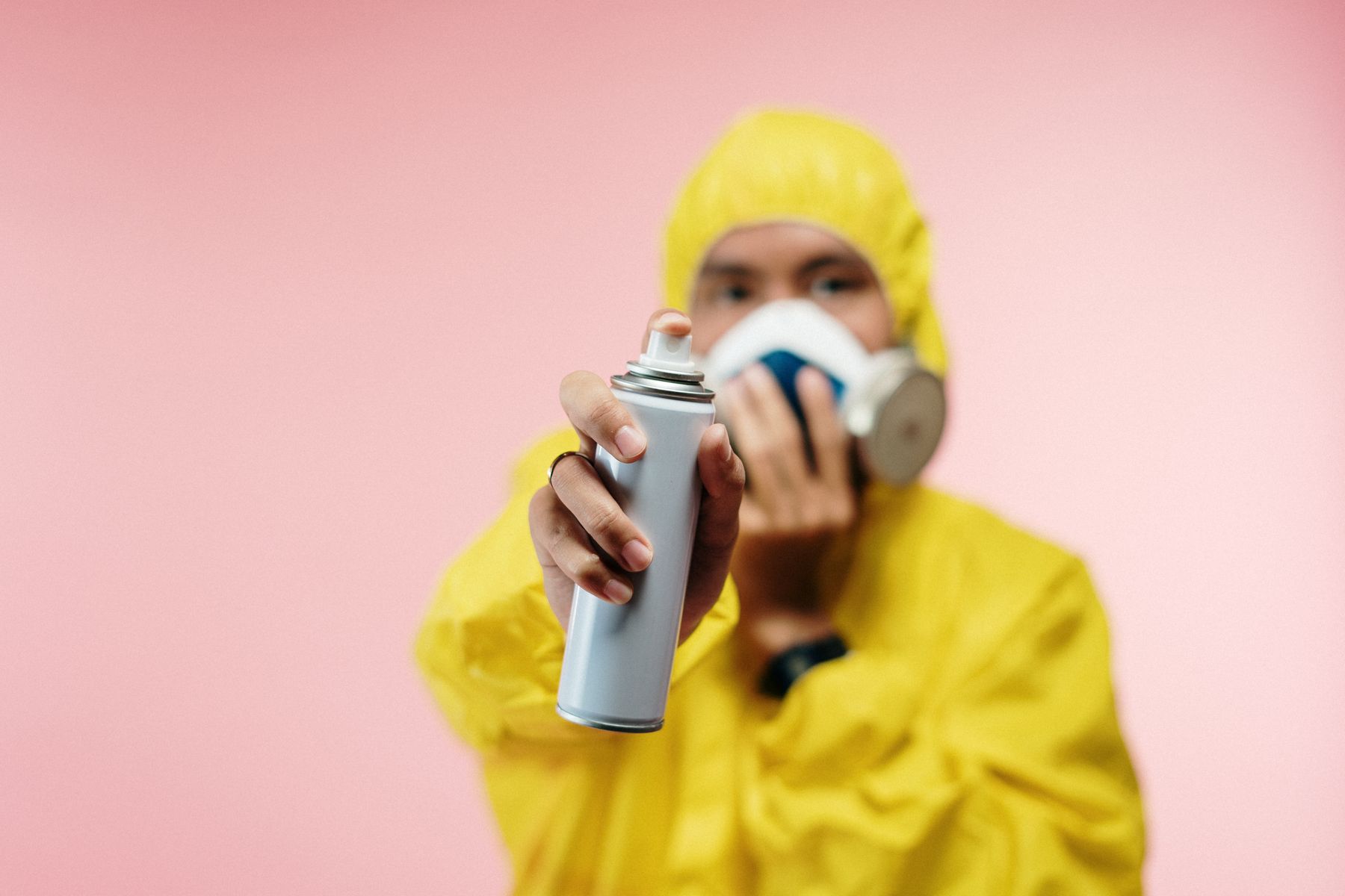 A man in protective gear holding an aerosol can