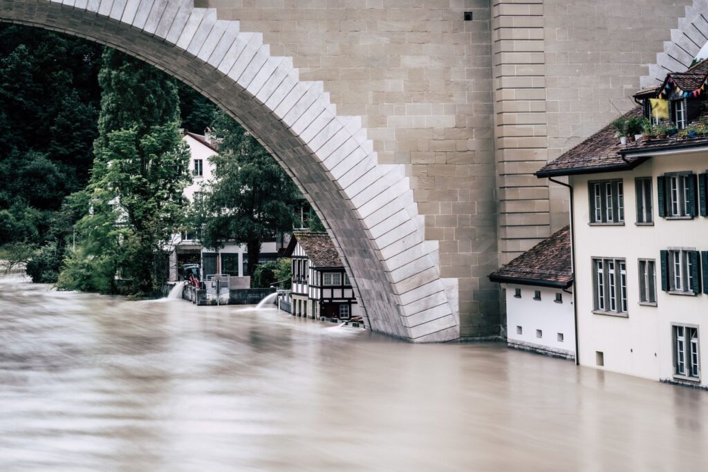 Floodwater surrounding homes beneath a bridge