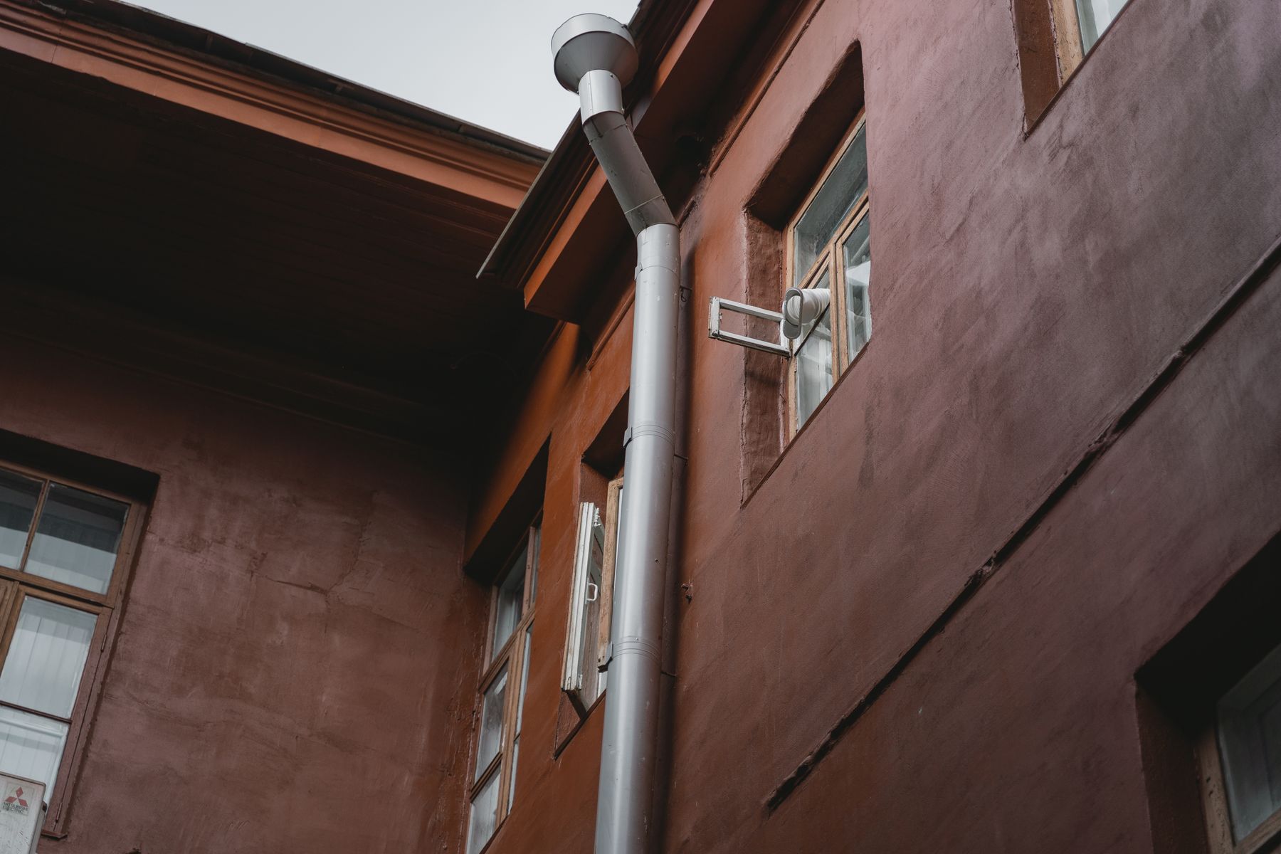 Exterior wall with metal ventilation pipe and windows