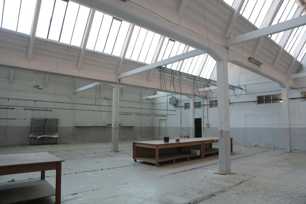 Empty industrial warehouse with skylights and work tables
