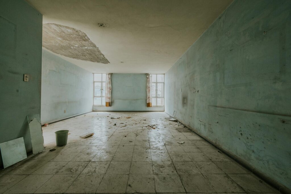 Empty room showing water damage and peeling paint