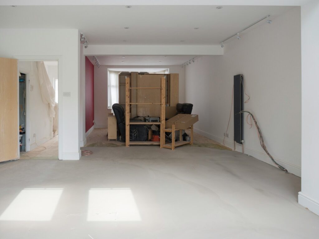 Empty room mid-renovation with construction materials stacked in the center