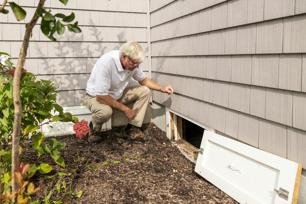 Home inspector checking crawl space for moisture and mold