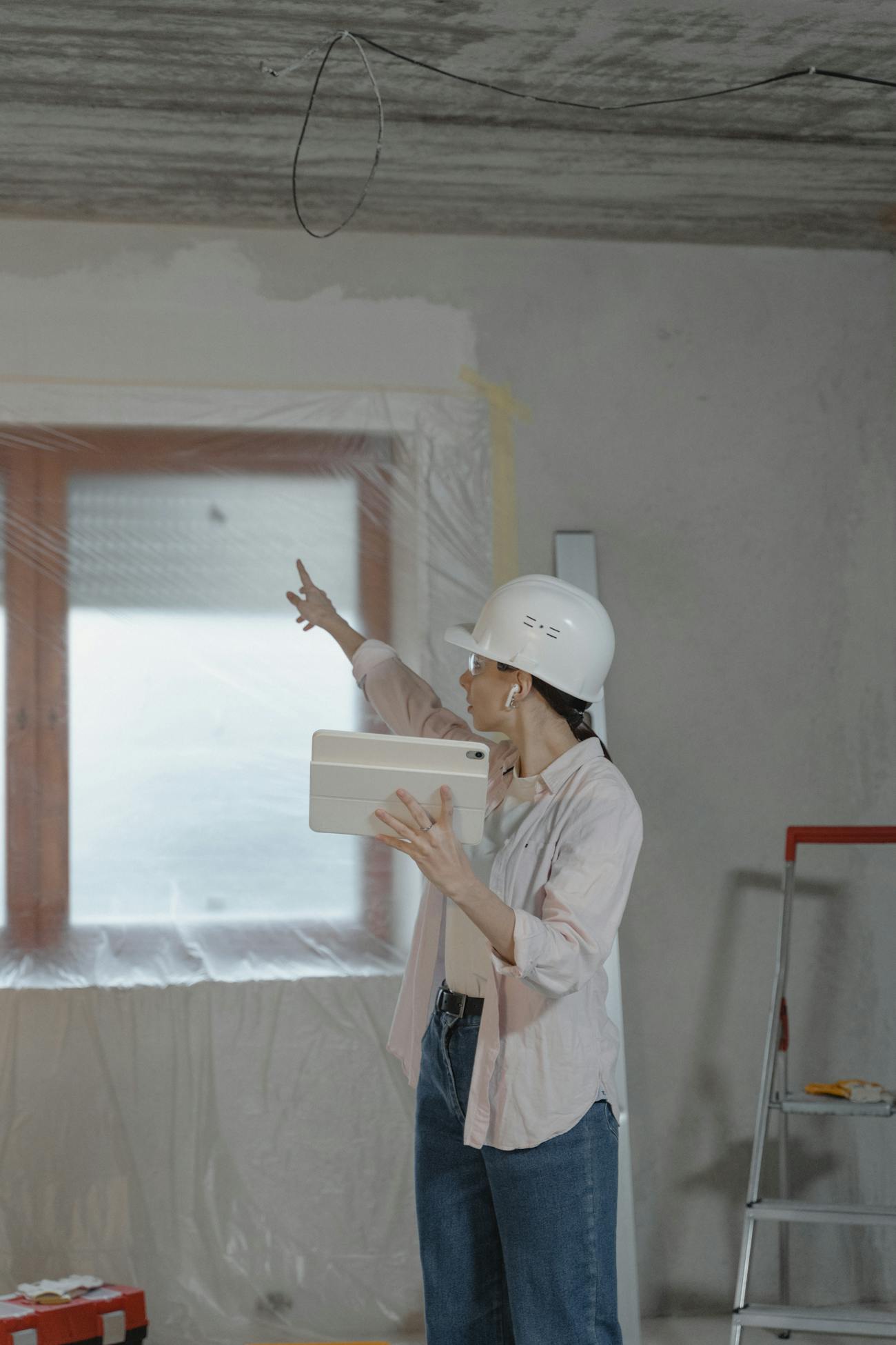Contractor in a hard hat pointing at the ceiling during an inspection