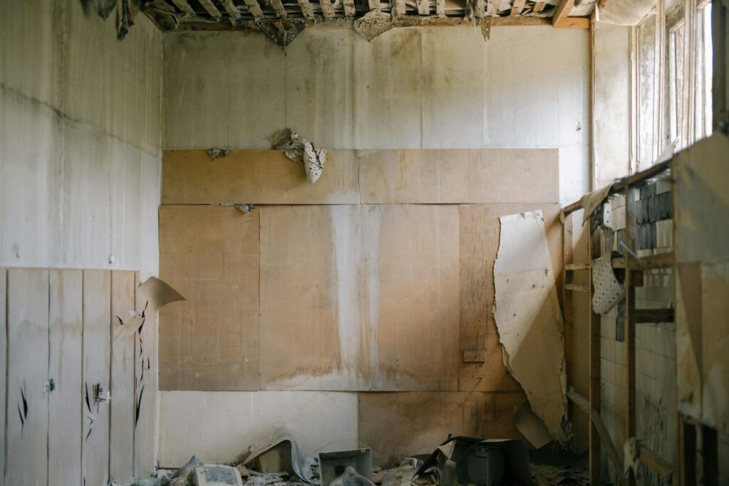 Damaged room with water-stained walls and exposed ceiling beams