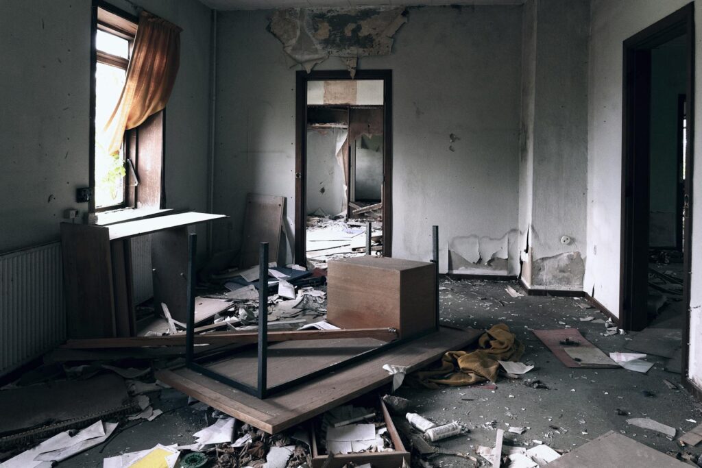 Debris-filled room with damaged walls
