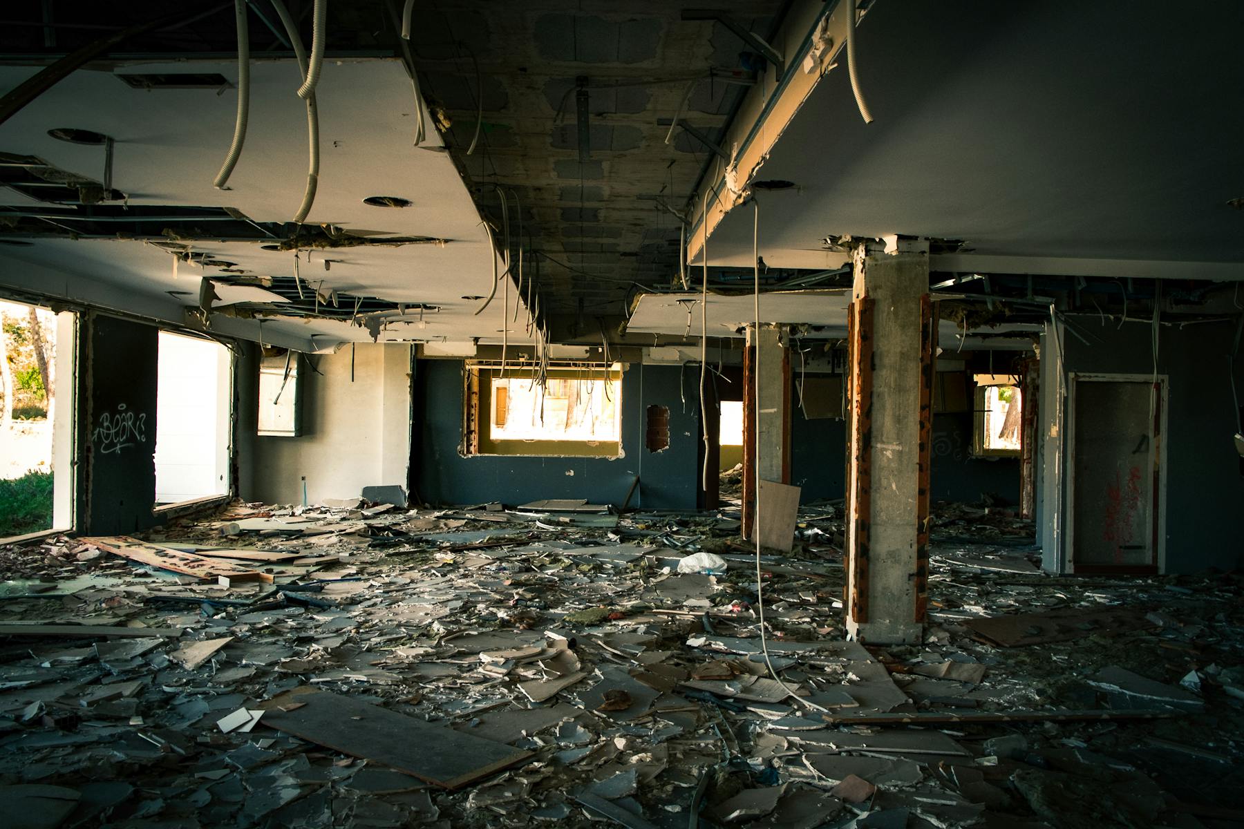 Damaged interior with exposed ceiling and debris