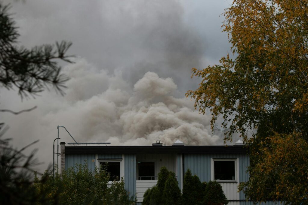 Dense smoke rising above a residential building after fire
