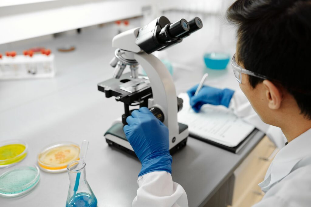 Lab technician examining samples under a microscope