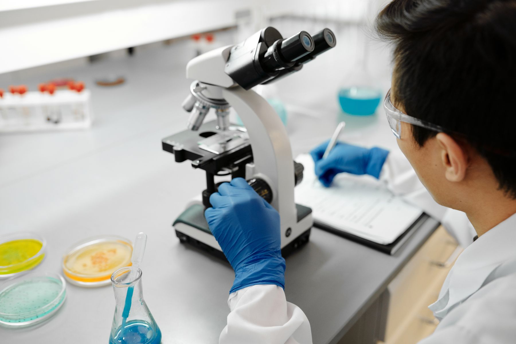 Lab technician examining samples under a microscope