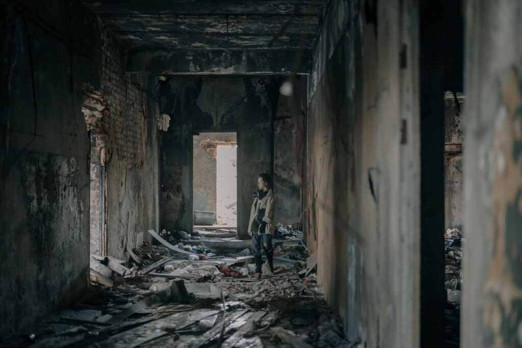 Person inspecting a fire-damaged building interior