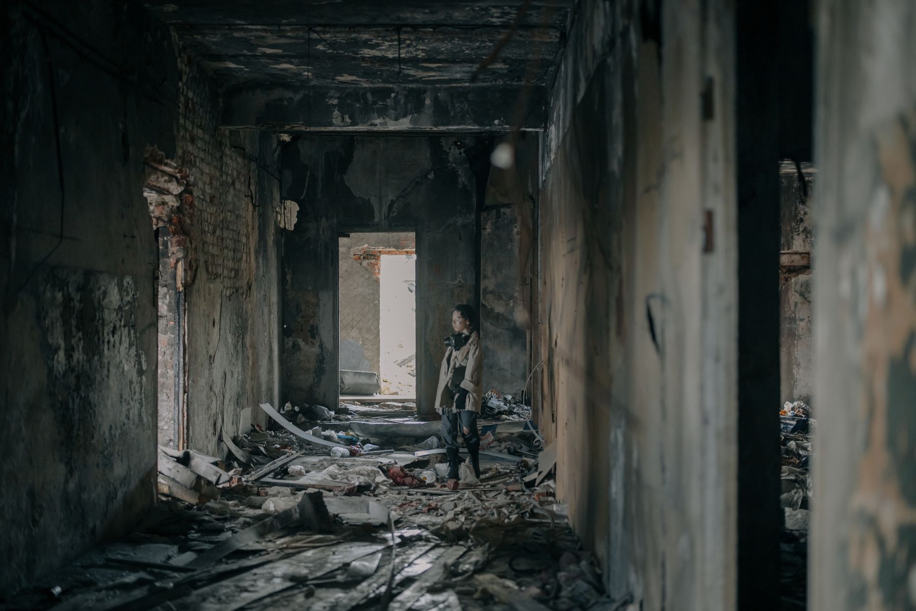 Person inspecting a fire-damaged building interior