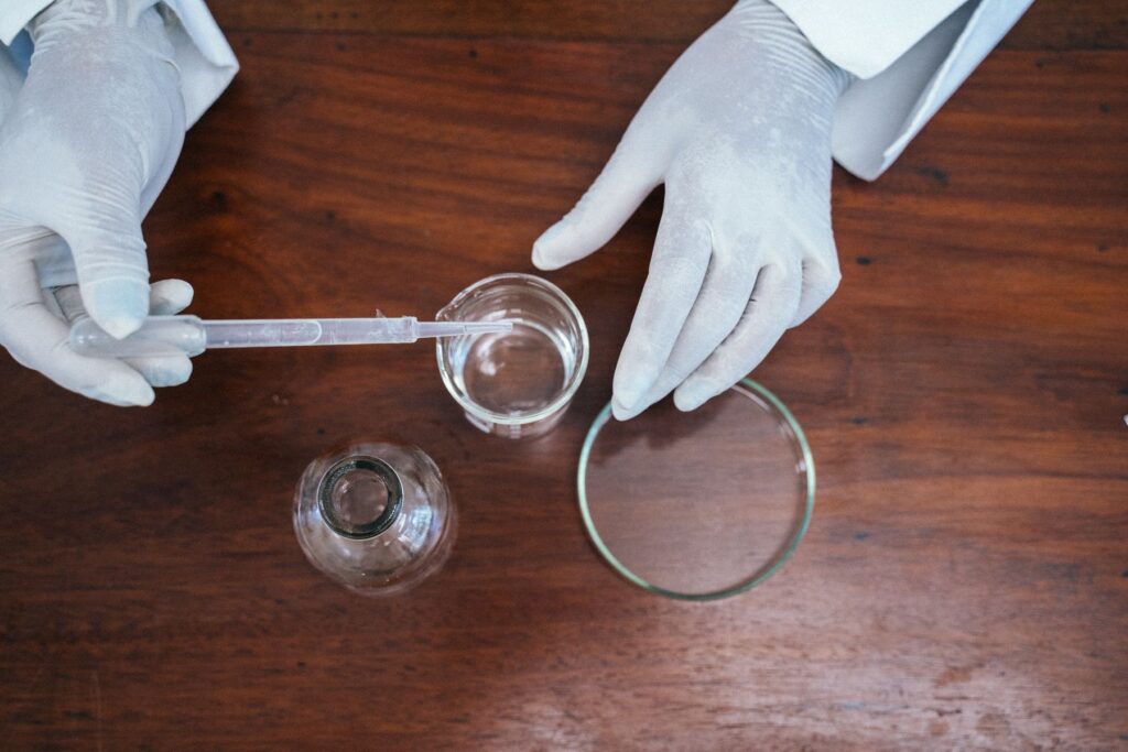 Gloved hands preparing a lab sample with a pipette