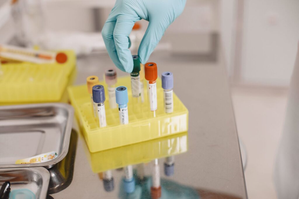 Gloved hand handling sample tubes in a lab
