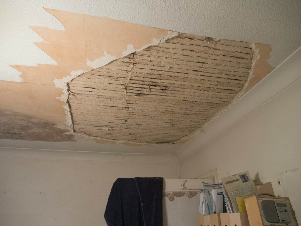 Close-up of damaged ceiling with exposed material