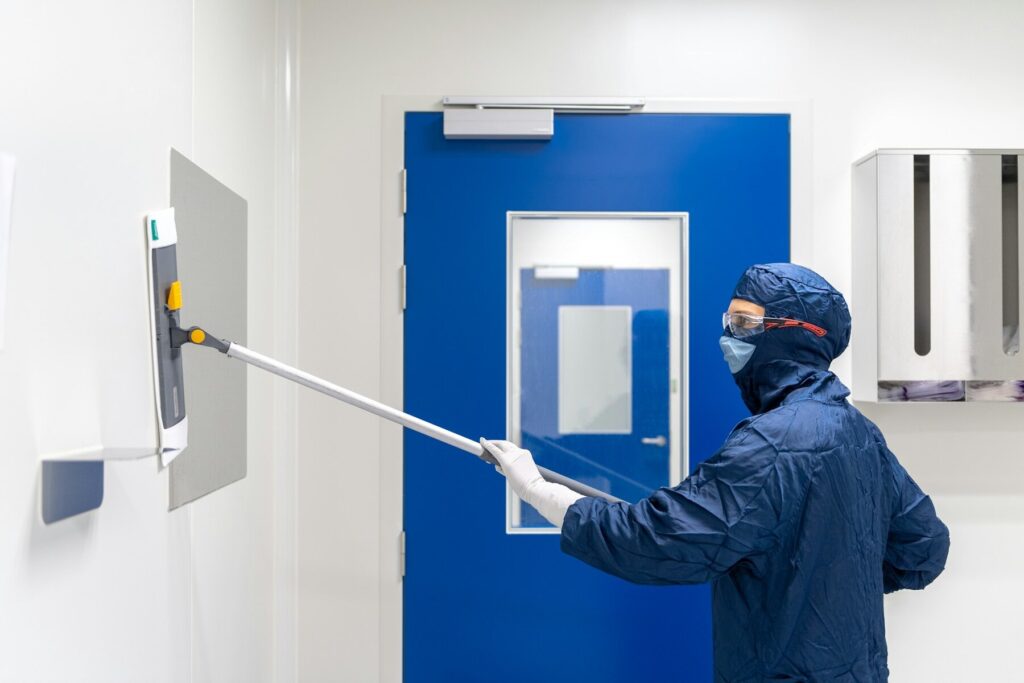 Technician in protective gear performing asbestos surface testing
