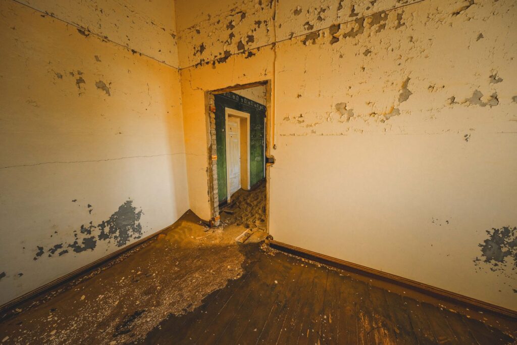 Damaged interior room with peeling paint and deteriorating walls