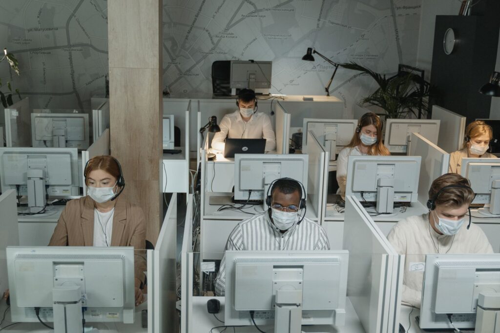 Office employees wearing masks while working at computer stations
