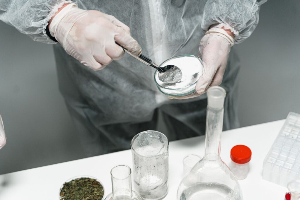 Lab technician handling a powdered sample with protective gloves