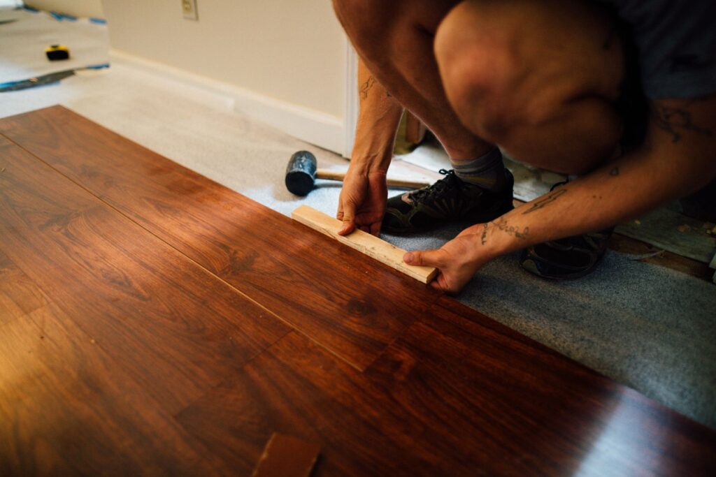 Worker installing wood flooring during a home renovation