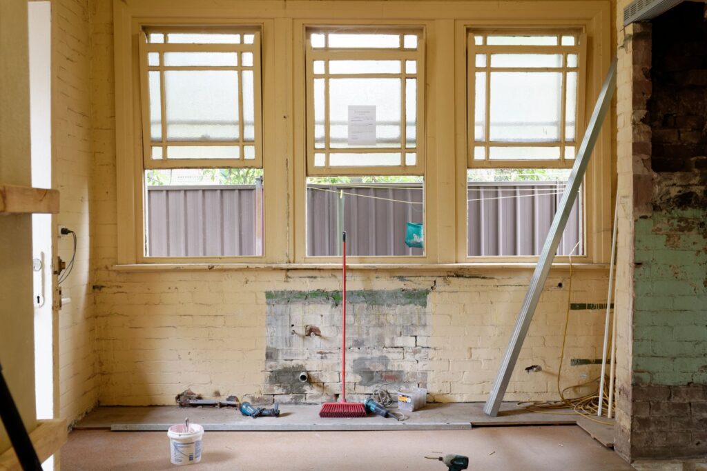 Interior room undergoing renovation with exposed walls and construction tools