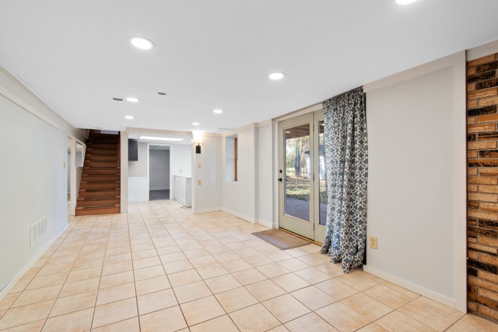 Bright finished basement with tile flooring and patio doors
