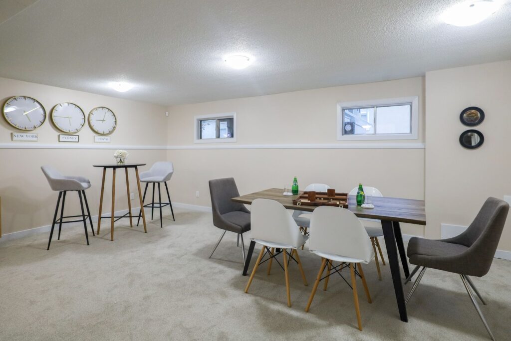 Finished basement with dining table, chairs, and small windows