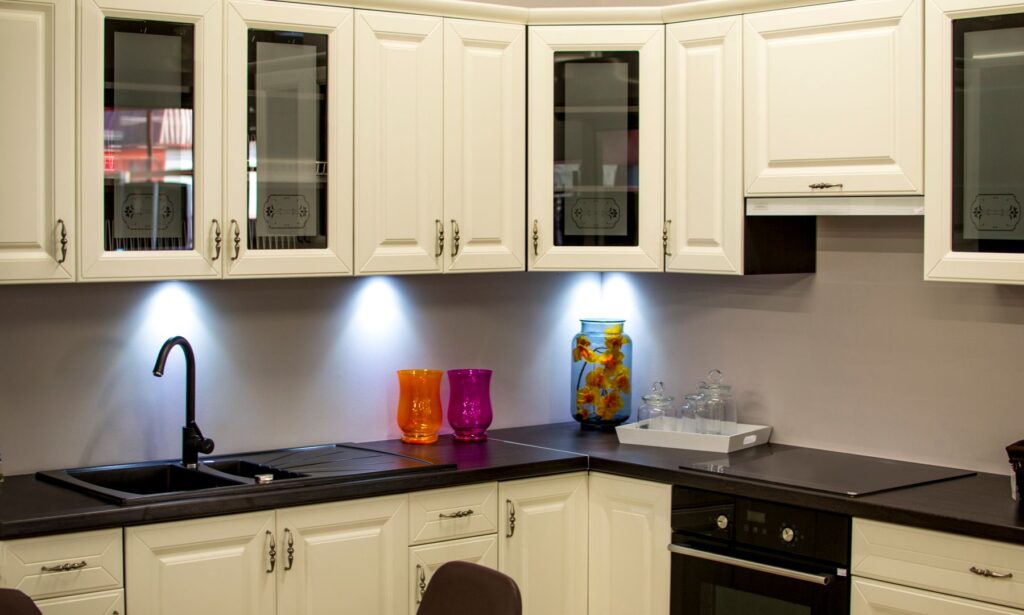 Kitchen with cream cabinets, black countertops, a sink, and built-in oven